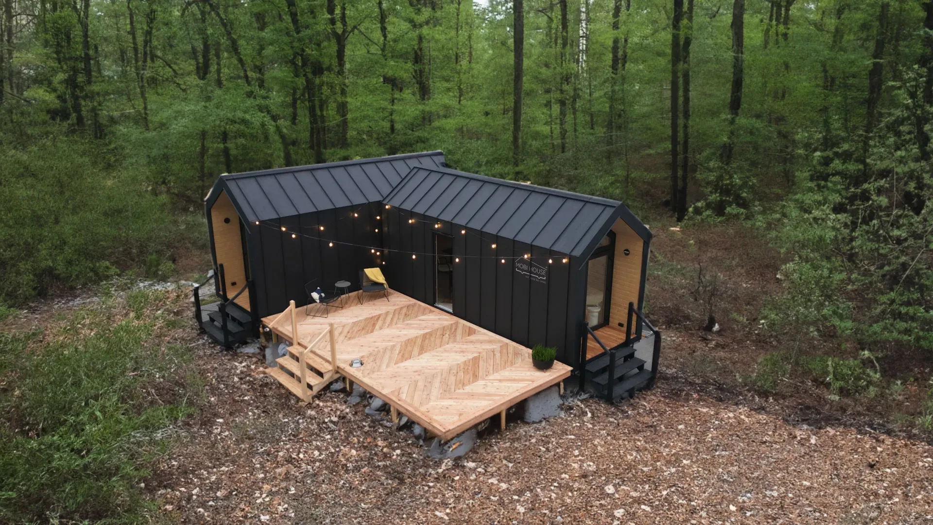 Zwei kombinierte Module mit gemeinsamer Holzterrasse im Wald