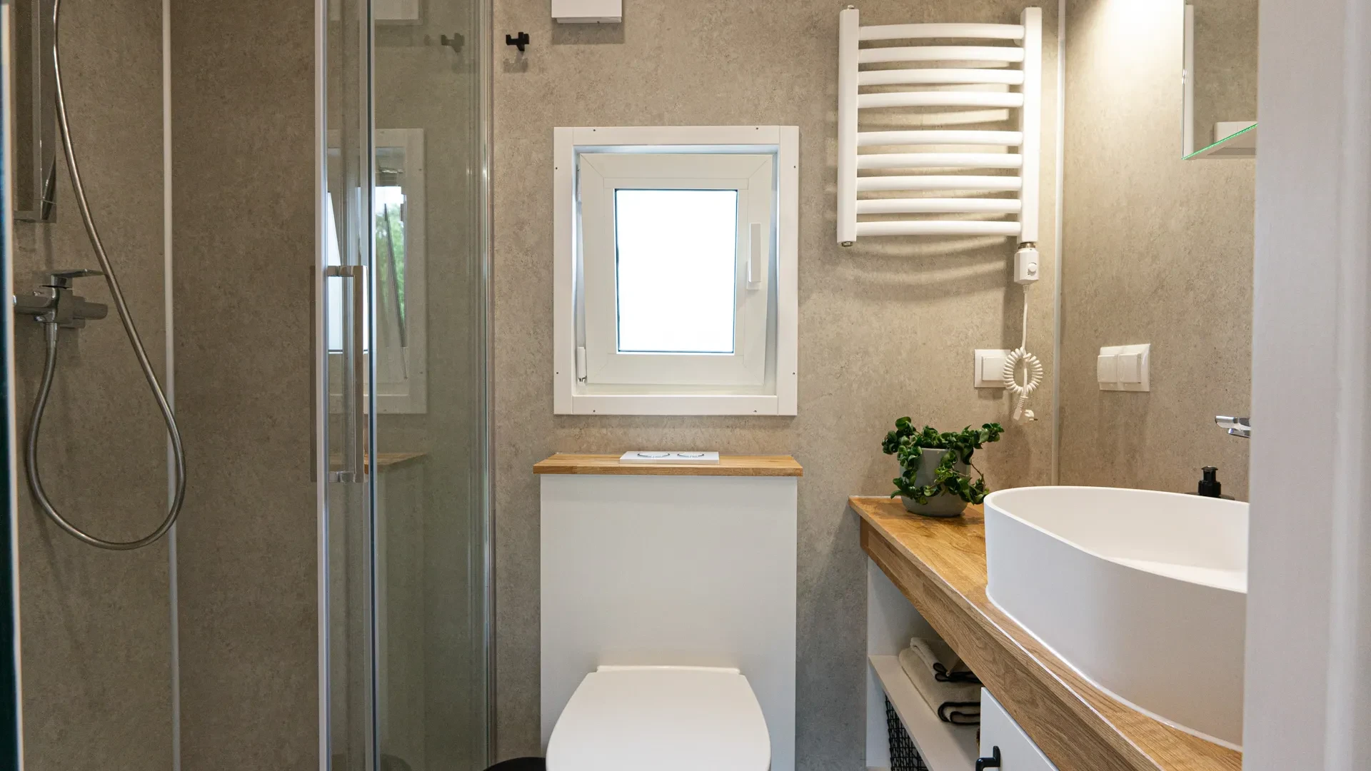Badezimmer mit Dusche, WC und Handtuchheizkörper